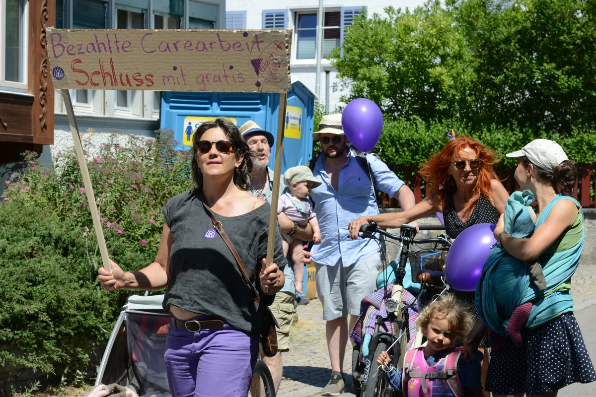 Das Thema Care-Arbeit war an der Demonstration omnipräsent, nicht nur auf diesem Schild. Frau an Demonstration, die ein Schild hochhält mit der Aufschrift «Bezahlte Carearbeit, Schluss mit gratis».